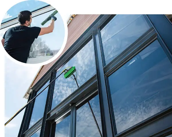 Immaculate SoftWash technician cleaning a building exterior with a water-fed pole brush